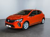 La voiture orange est garée dans une pièce blanche.