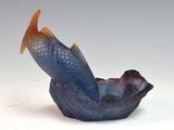 a blue and orange fish in a bowl on a white surface