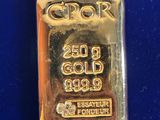 a close up of a gold bar on a blue surface