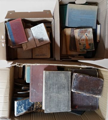 Des cartons remplis de livres sont empilés les uns sur les autres sur une table