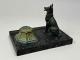 statue of a dog sitting on a base next to a lamp