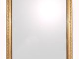 a gold framed mirror with a white background and a white wall