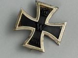 an iron cross pin with a black and gold cross on it