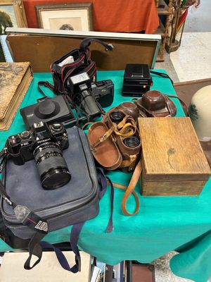 une table bleue sur laquelle se trouvent un appareil photo, un étui à appareil photo et d'autres objets