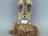 une image représentant un masque en bois sur lequel est accrochée une étiquette