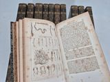 many old books sitting on top of each other on a table