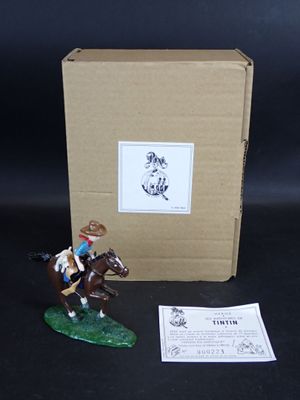 une figurine représentant un homme à cheval, à côté d'une boîte