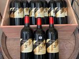 plusieurs bouteilles de vin rouge dans une caisse en bois posée sur un tonneau