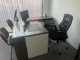 a desk with a chair and a computer on it