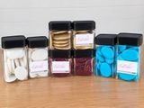 five jars with different colored cookies in them on a table