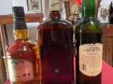 three bottles of alcohol sitting on a table in a room