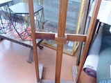 a wooden easel with a painting on it in a room