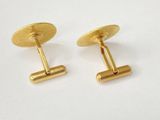 two pairs of gold cufflinks on a white surface