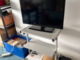 un téléviseur à écran plat posé sur un support dans le coin d'une pièce