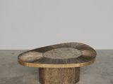 une table ovale en bois avec un piètement en métal, dans une pièce