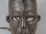une image représentant un masque en bois entouré d'une corde