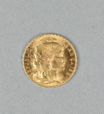 gros plan d'une pièce d'or sur une surface blanche