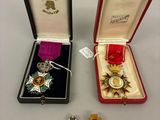 Deux médailles se trouvent dans un écrin rouge et une médaille d'or se trouve dans une boîte noire