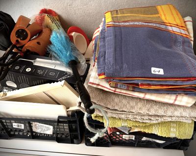 a pile of folded towels and other items on a shelf
