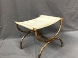 un tabouret doré et blanc sur un fond gris, avec une toile de fond grise