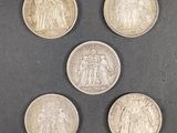 six pièces britanniques différentes sont disposées en cercle sur une surface noire
