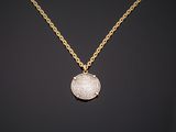 a gold necklace with a coin on a chain