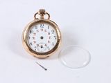 a gold pocket watch with a white face on a white surface