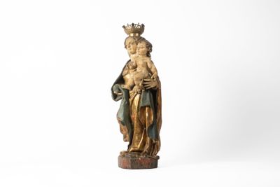 une statue ancienne d'une femme tenant un bébé dans ses bras