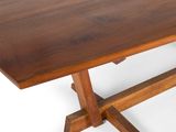 the table is made of wood and has a cross leg base