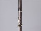 a close up of a silver and black clarinet on a clear surface