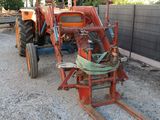 a red tractor that is parked in the dirt