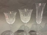 three clear wine glasses sitting on top of a table next to each other