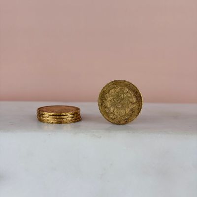 a gold coin sitting on top of a white counter next to a stack of coins