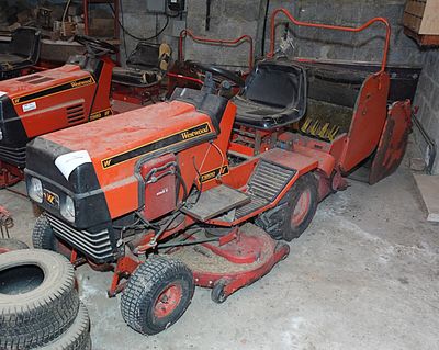 deux tondeuses à gazon et un tracteur dans un garage