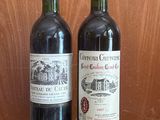 two bottles of wine sitting next to each other on a table