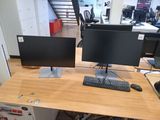 a computer desk with two monitors and a keyboard on it