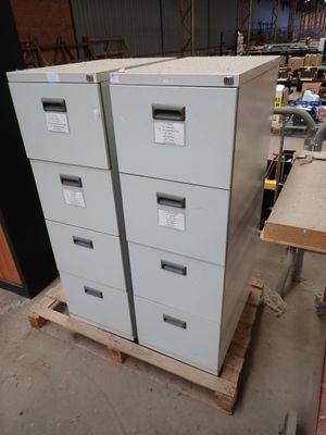 une pile de classeurs posée sur une palette dans un entrepôt