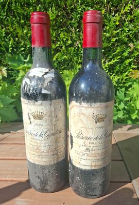 two bottles of wine sitting on a wooden table
