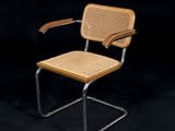 La chaise est en métal et en osier, avec une assise en bois.