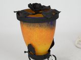 a yellow and black vase with a black flower on it