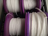 a basket full of white and purple rope on a table