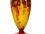 a yellow vase with brown designs on it on a white surface