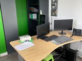 un bureau sur lequel sont posés deux écrans et un ordinateur portable
