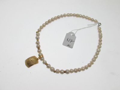 gros plan d'un collier sur une surface blanche avec une étiquette