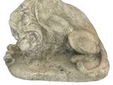 une statue représentant un chien couché sur un rocher