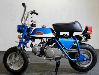 a small blue motorcycle parked in a garage