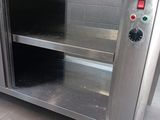 a stainless steel counter with a shelf on top of it