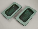 pair of green ceramic ashtrays on a white table