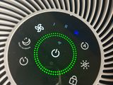 un purificateur d'air posé sur une table, à côté d'une télécommande