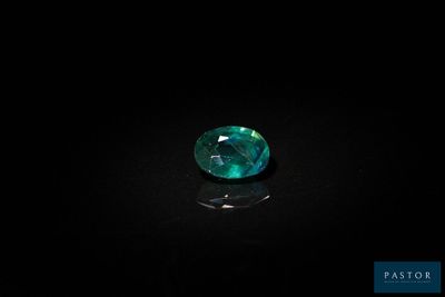 a close up of a green gemstone on a black surface
